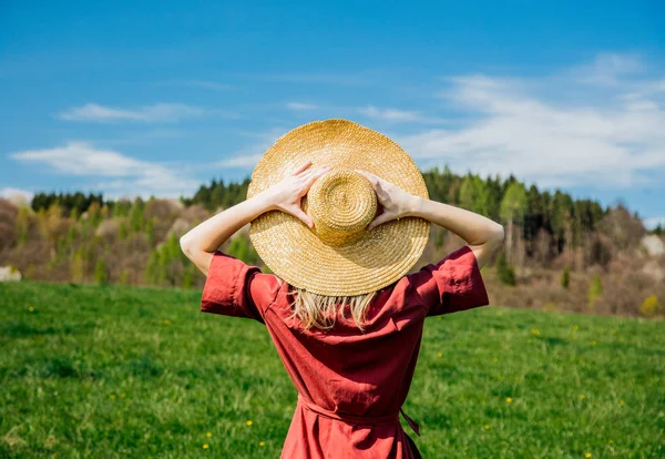 Krásná dívka v červených šatech a v klobouku má na medoviny bezstarostně volný čas — Stock fotografie