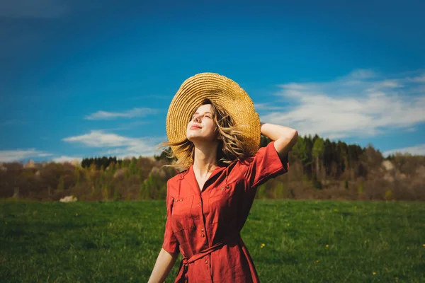 Mooi meisje in rode jurk en hoed hebben een zorgeloze tijd op Mead — Stockfoto