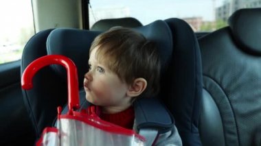 Küçük çocuk hareket ederken şemsiye ile bir araba sandalyede oturan 