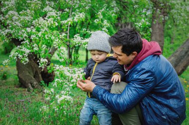 Genç baba oğluna çiçek açan ağacı gösterir. 