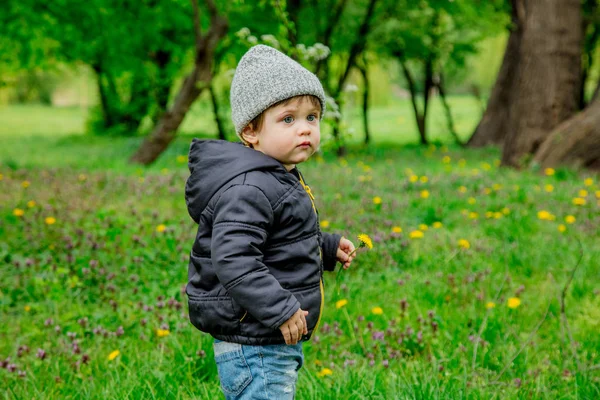 Menino de casaco e chapéu no parque de tempo de primavera — Fotografia de Stock