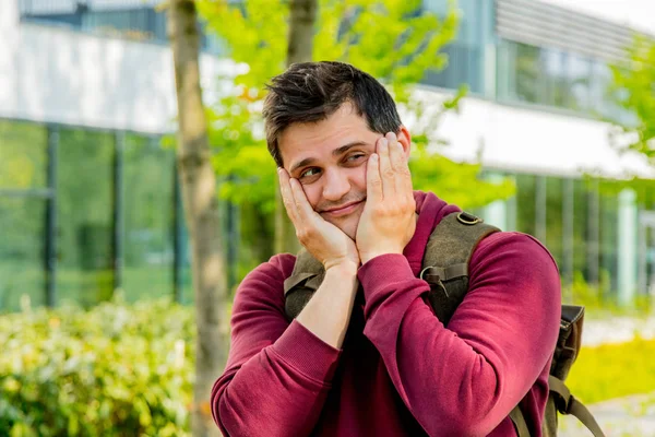 Joven con mochila estancia en callejón cerca de edificio moderno de Un —  Fotos de Stock