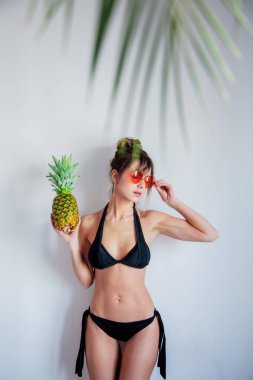 Kadın bikini tutan ananas ve palmiye yaprakları ile f