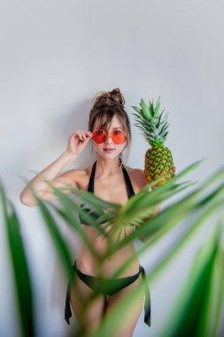 Kadın bikini tutan ananas ve palmiye yaprakları ile f
