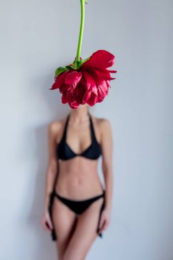 Ön planda şakayık çiçek ve backgrou siyah bikini kadın