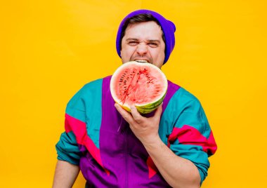 90 'ların kıyafetleri içinde karpuzlu genç adam.