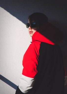 Kapüşonlu ceketli stil kız gölgeli balkonda kalıyor. 