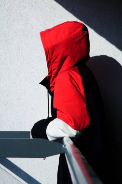 Kapüşonlu ceketli stil kız gölgeli balkonda kalıyor.
