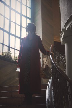 Sütlü ve elinde ağ torbasıyla genç bir kadın.