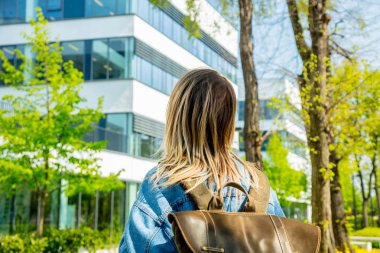 Bir sırt çantası ile genç bir öğrenci kampüs yakınında ilk kez