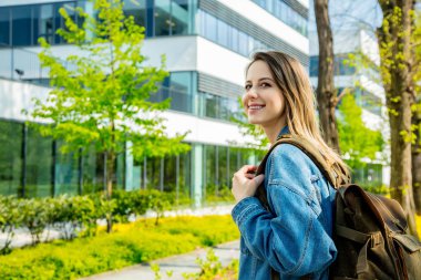 Bir sırt çantası ile genç bir öğrenci kampüs yakınında ilk kez