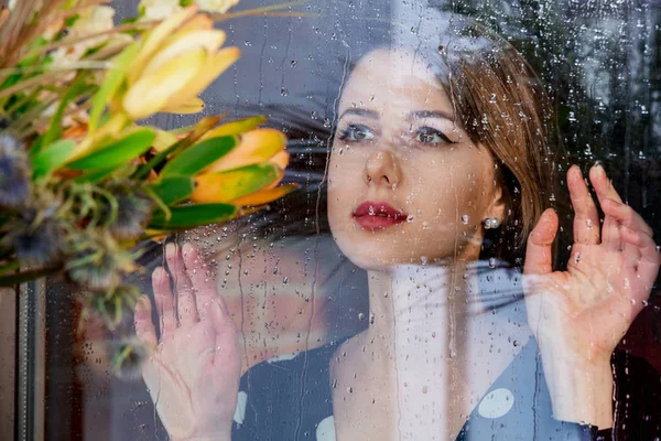 Jovem mulher triste na janela molhada após a chuva perde o plano — Fotografia de Stock