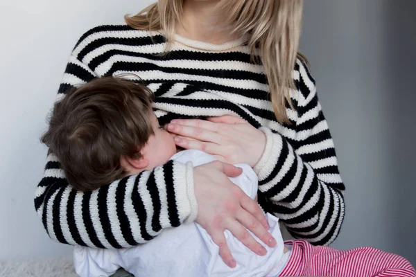 Jovem mãe amamentando menino criança em camisola listrada — Fotografia de Stock