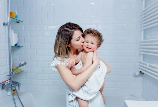 Mãe e menino depois do banho. A mãe a beijar um bebé. Criança — Fotografia de Stock