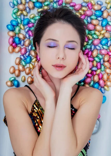 Jeune femme couchée sur un chocolat oeufs de Pâques . — Photo