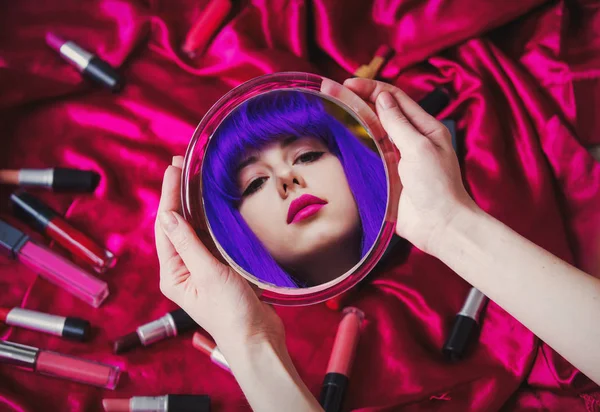 Giovane donna con i capelli viola guardando in uno specchio — Foto Stock