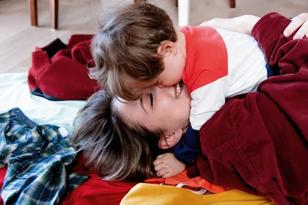 Молода мама і маленький хлопчик обіймається на підлозі — стокове фото