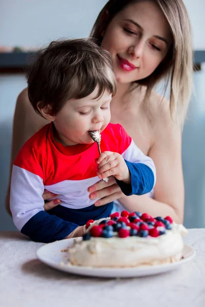 Мать и сын едят сливочный пирог с черникой и малиной — стоковое фото