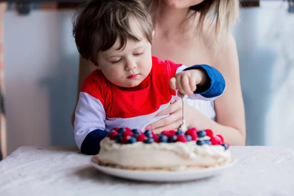 Mãe e filho comendo torta de creme com mirtilos e framboesas — Fotografia de Stock