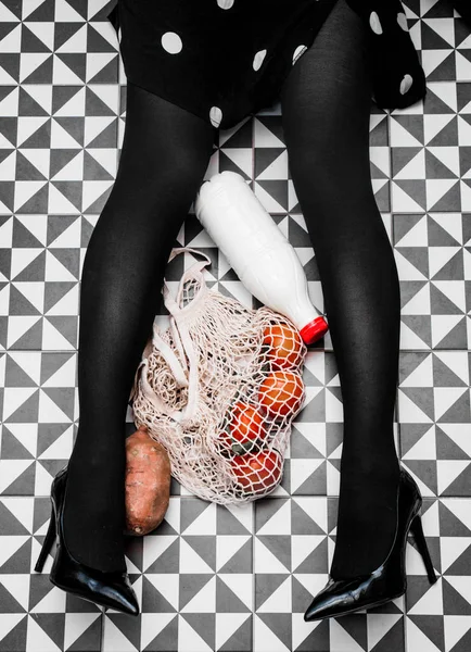Donna seduta su un pavimento con borsa e bottiglia di latte, carota e a — Foto Stock