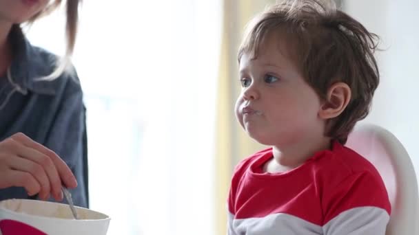 Evde Beslenme Sırasında Bir Sandalyede Oturan Küçük Yürümeye Başlayan Çocuk — Stok video