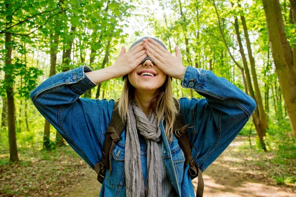 Woman with backpack hide face with a scarf in forest — Stock Photo, Image