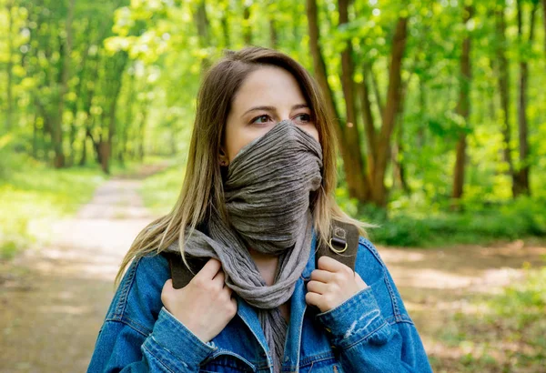 Mulher com mochila esconder rosto com um lenço na floresta — Fotografia de Stock