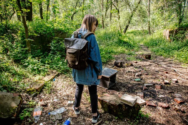 Nő hátizsák közelében szemét egy erdőben — Stock Fotó