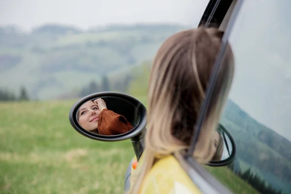 Женщина, сидящая в маленькой машине на месте водителя — стоковое фото