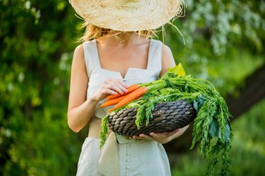 Baharda açık havada sebze sepeti olan genç bir kadın.