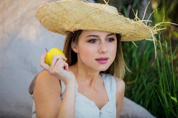 Młoda kobieta w kapeluszu z jabłkiem — Zdjęcie stockowe