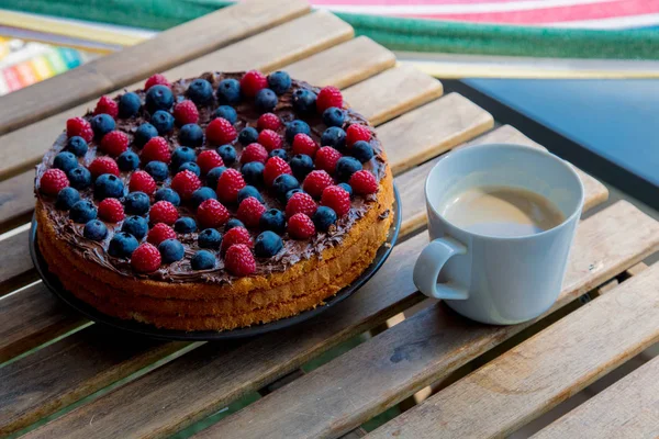 Chocolate covered blueberry and raspberry tart with coffee cu — Stock Photo, Image