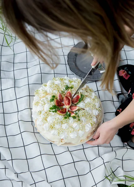 La donna taglia una torta alla panna all'aperto in tempo di primavera — Foto Stock