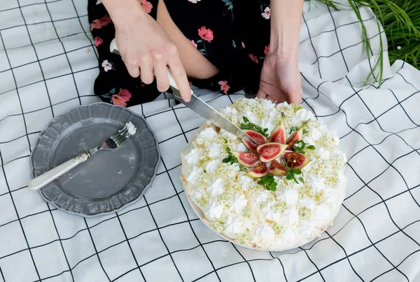 Woman cut a cream pie at outdoor in spring time — Stock Photo, Image