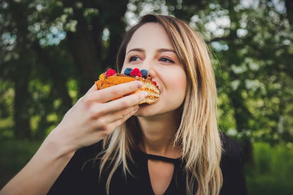 Kobieta jedząca czekoladę pokrytą jagodami i maliną — Zdjęcie stockowe