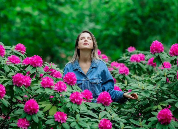 Donna di stile vicino a fiori di rododendro in un grarden in primavera tim — Foto Stock