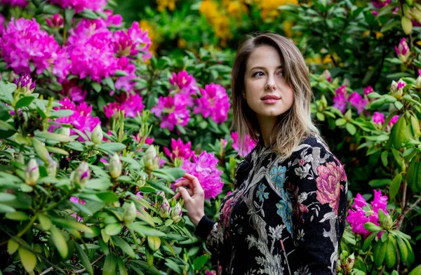Ženská ve stylu u rododendronů v grardenu na jaře — Stock fotografie