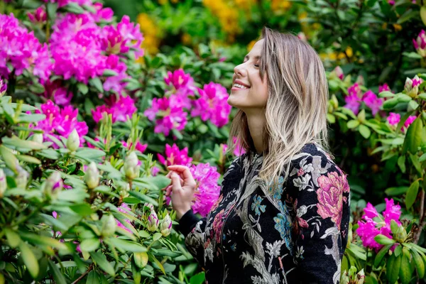 Ženská ve stylu u rododendronů v grardenu na jaře — Stock fotografie