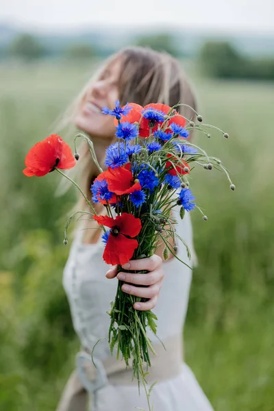 若いです女性のドレスでフィールドの近くに滞在花束のCentaureaとPoppy花 — ストック写真