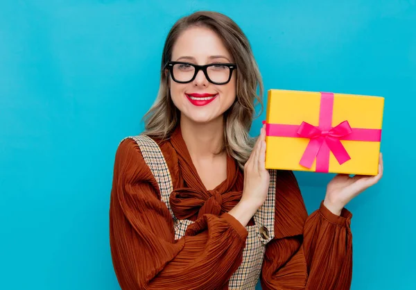 Mujer joven con caja de regalo amarilla —  Fotos de Stock