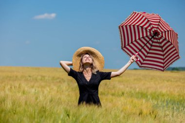 Siyah elbiseli kadın ve kırmızı şemsiyeli şapka buğday fi kalmak