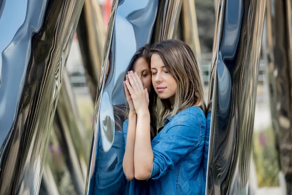 Woman stay near metal construction with reflection — 스톡 사진