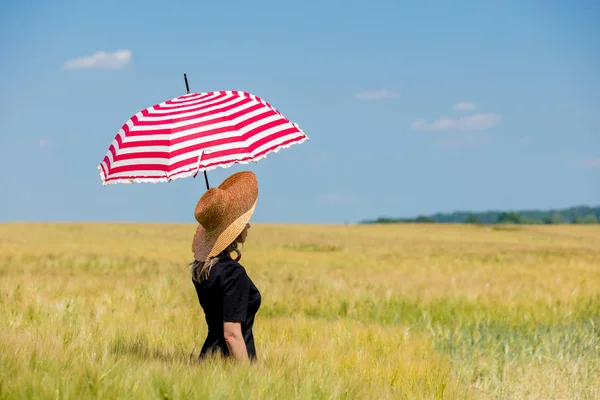 Siyah elbiseli kadın ve kırmızı şemsiyeli şapka buğday fi kalmak — Stok fotoğraf