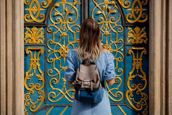 Back view of a girl with a backpack standing near a beautiful do — Stock Photo, Image