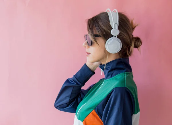 Jonge vrouw in de jaren 90 stijl kleren met koptelefoon — Stockfoto