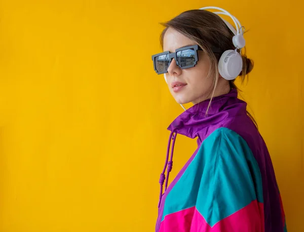 Jonge vrouw in de jaren 90 stijl kleren met koptelefoon — Stockfoto