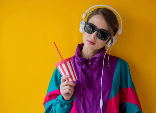 Fiatal nő a 90-es évek stílusú ruhákat a csésze és fejhallgató — Stock Fotó
