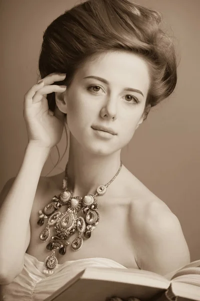 Portrait de rousse edvardian femmes avec livre sur fond rouge . — Photo