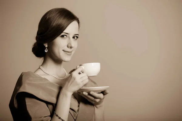 Woman in red Victorian epoch clothes with cup of tea — Stock Photo, Image