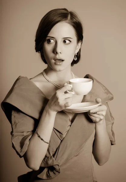 Жінка в червоній вікторіанській епохи одяг з чашкою — стокове фото